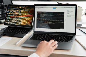 Fachinformatiker für Systemintegration arbeitet am Laptop mit Code und IT-Systemen im Rahmen der Umschulung (IHK)